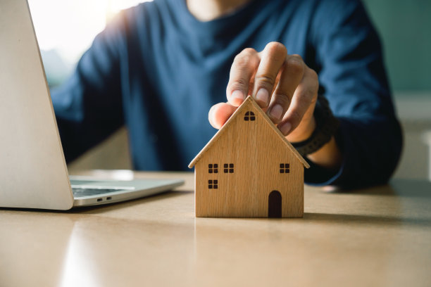 商业手握家与买或租，复制空间。物业投资和房屋抵押贷款的金融概念，手放钱硬币堆叠与木屋。图片下载