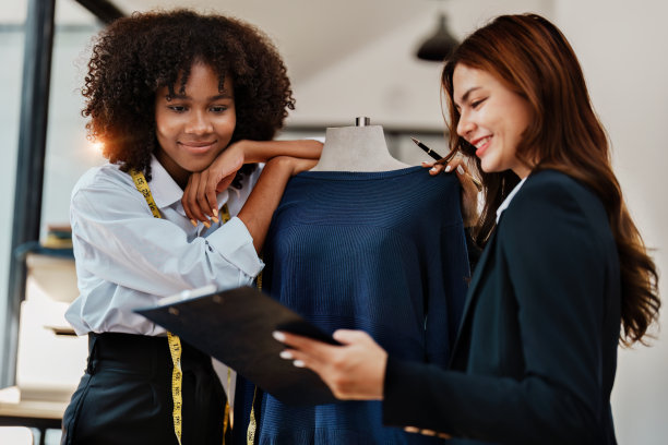 多种族年轻的非裔美国人和亚洲女性时装设计师时尚和朋友在时尚商业工作室工作图片下载