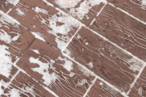 公园里的铺路板在冬天的树下，以雪为背景图片下载