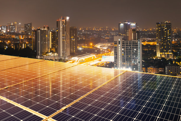 高层建筑屋顶上的太阳能电池板为城市生活供电。企业、家庭、智能城市和新一代能源的可持续能源。清洁环保。图片下载