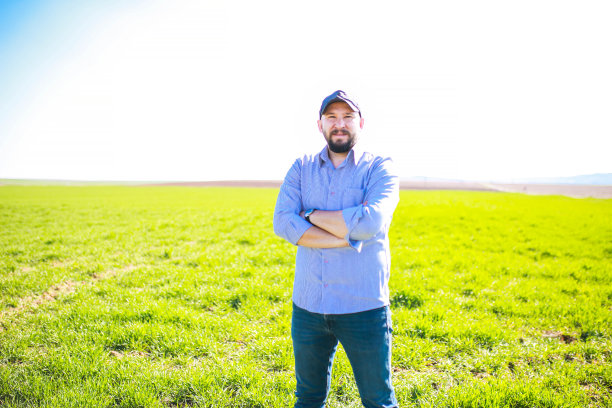 年轻的农学家双臂交叉在田里图片下载