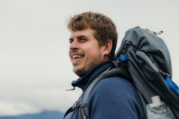 男子背着背包在挪威的夏季山区徒步旅行的肖像图片下载