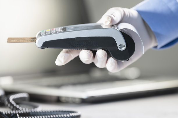 男性手戴手套，手持信用卡读卡器图片下载