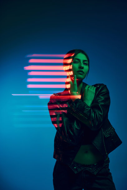 半长的肖像，年轻的时尚女子在深蓝色的背景与霓虹灯混合光线。当代艺术，时尚，赛博朋克，未来主义的概念图片下载