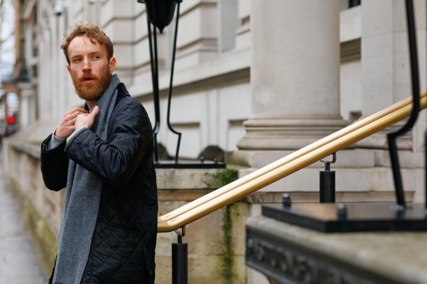 一个时尚的野蛮人的肖像与胡子在城市街道上摆姿势图片下载