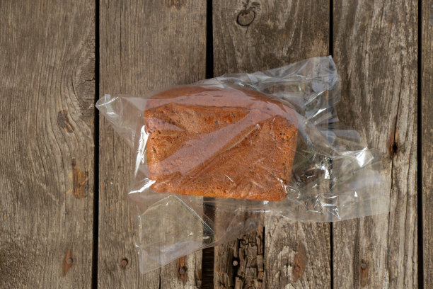 桌上有一条透明包装的黑面包图片下载