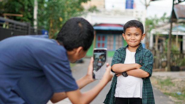 亚洲男孩和哥哥在户外使用智能手机图片下载