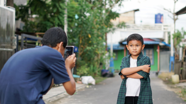 亚洲男孩和哥哥在户外使用智能手机图片下载