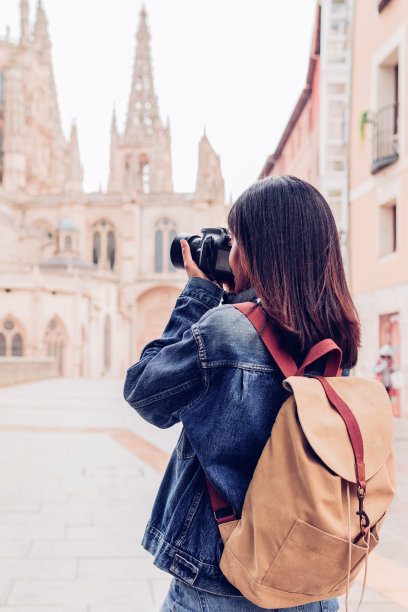 年轻的女摄影师用数码相机拍照。旅行和积极的生活方式概念图片下载