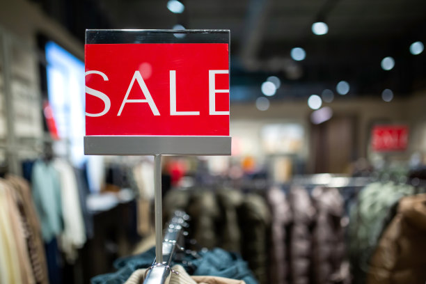 现代商场服装货架上的红色打折标志。图片下载