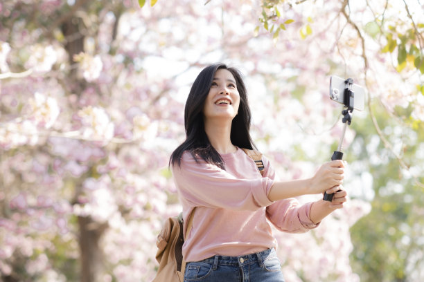 亚洲女性喜欢用美丽的花朵，旅行放松的理念。图片下载