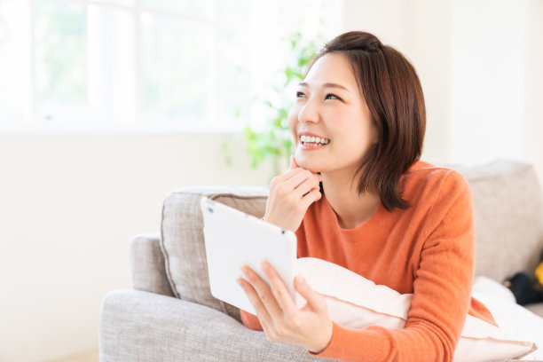 有魅力的亚洲女子使用平板电脑图片下载