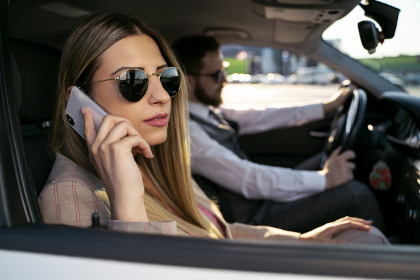 特写镜头的现代商业女性坐在汽车的副驾驶座位上，打电话图片下载