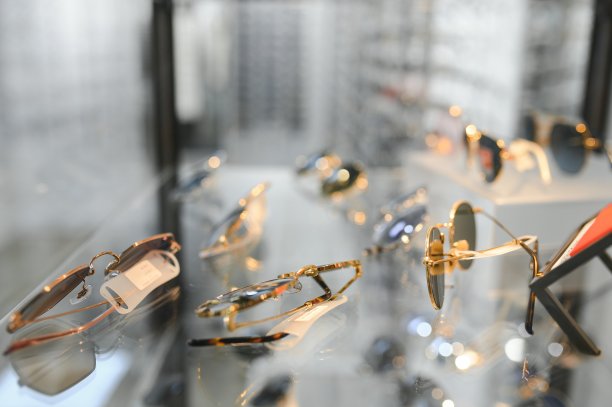 戴上太阳镜站着。在城市市场或商店出售太阳镜。时尚太阳镜，夏季眼镜，时尚系列，不同的太阳镜在一个架子上图片下载