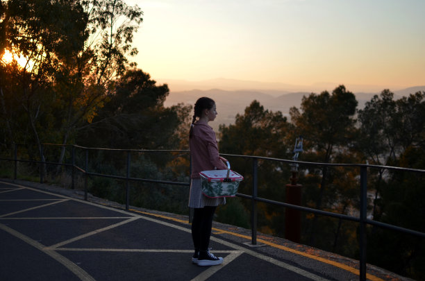 大自然中的女孩拿着野餐篮往下看图片下载