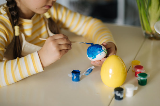 小女孩在厨房种植复活节彩蛋的微距照片。黄色和蓝色。乌克兰的象征图片下载