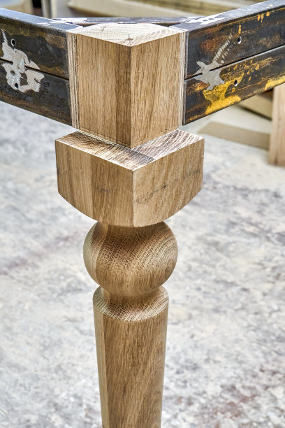 在车间制造桌子时，雕刻腿上的金属桌架图片下载