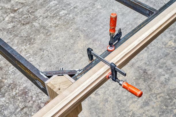 在车间制造桌子时，雕刻腿上的金属桌架图片下载