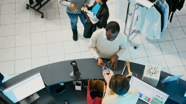 年轻顾客用信用卡买时髦衣服图片下载