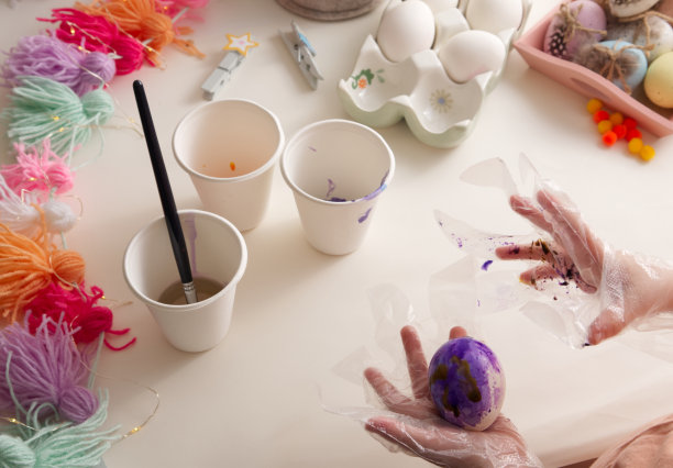 孩子们的手用春天装饰桌面视图的元素绘制复活节彩蛋图片下载