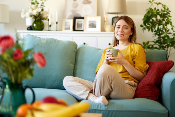 一个迷人的年轻女子在家里喝咖啡放松图片下载