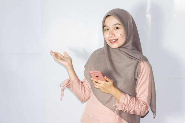 年轻的面纱妇女使用电话的肖像，孤立的背景图片下载