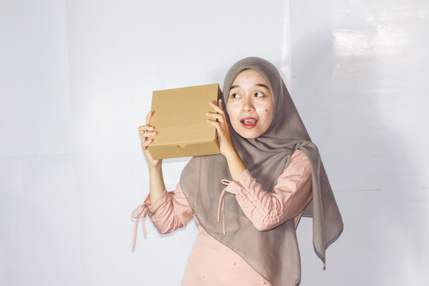 年轻的希贾布妇女与礼盒，快乐微笑的女孩手持惊喜礼物的肖像图片下载