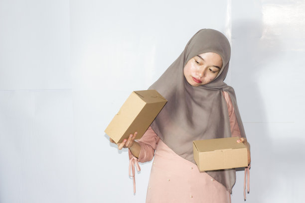 年轻的希贾布妇女与礼盒，快乐微笑的女孩手持惊喜礼物的肖像图片下载
