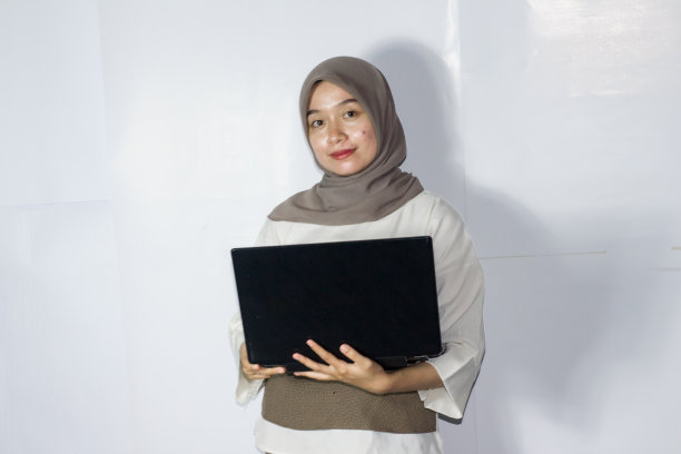 年轻的头巾妇女使用笔记本电脑的肖像图片下载