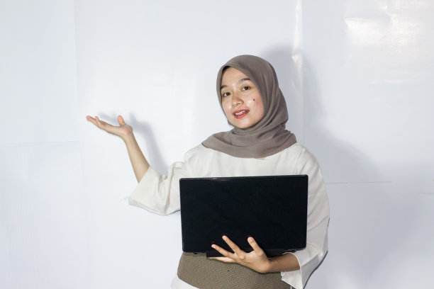 年轻的头巾妇女使用笔记本电脑的肖像图片下载