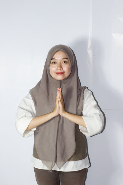 年轻的戴头巾的妇女示意穆巴拉克的问候图片下载