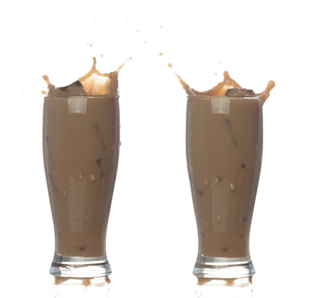 奶茶倒下来，形状呈直线。牛奶冰咖啡溅洒滴滴出玻璃，巧克力可可攻击飘动爆炸在空气中。白色背景隔离，停止运动图片下载