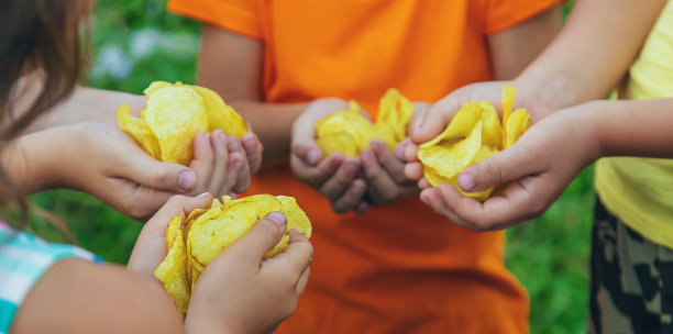 孩子们在街上吃薯片。有选择性的重点。图片下载