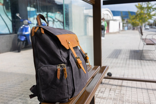 游客美丽的背包在长椅上停下，旅行者等待交通工具。图片下载