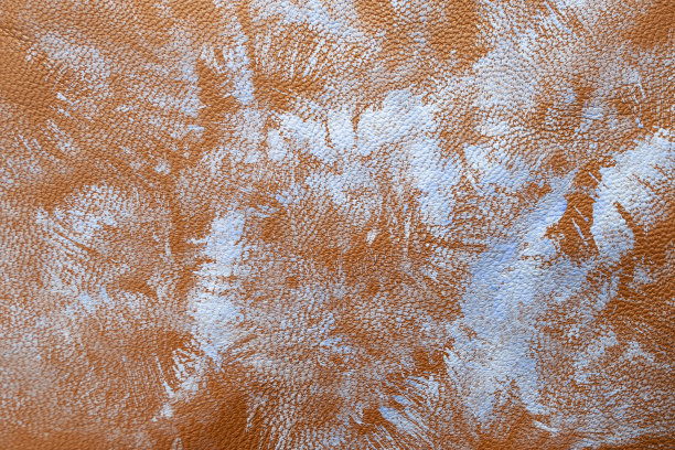 刷邮票笔画与蓝色油漆的红棕色皮革纹理图片下载