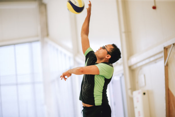 在室内玩沙滩排球的男性肖像。与人的生活方式体育摄影。多种族的人在体育馆里戴着太阳镜图片下载