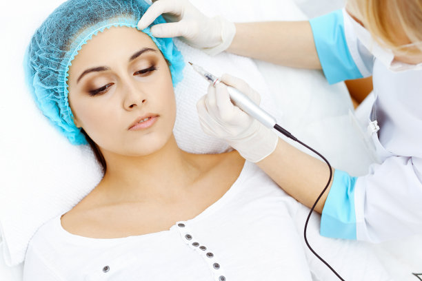 专业美容师在女人脸上做眉纹。在美容院的永久眉妆，特写。美容治疗图片下载