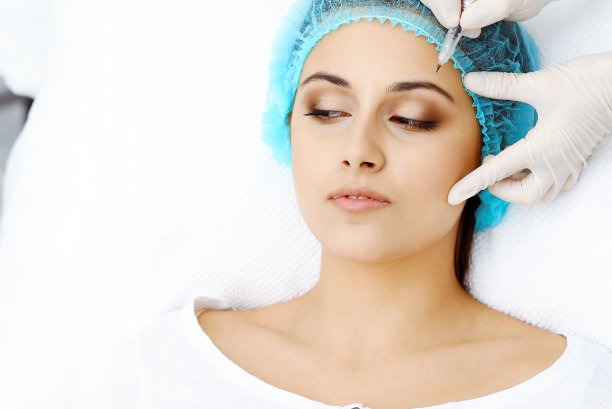 专业美容师在女人脸上做眉纹。在美容院的永久眉妆，特写。美容治疗图片下载