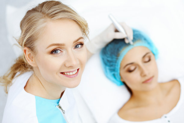 专业美容师在女人脸上做眉纹。在美容院的永久眉妆，特写。专注于专家。美容治疗图片下载