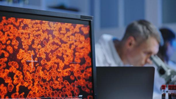 血液学实验室的科学家在显微镜下检查血液样本，医学图片下载