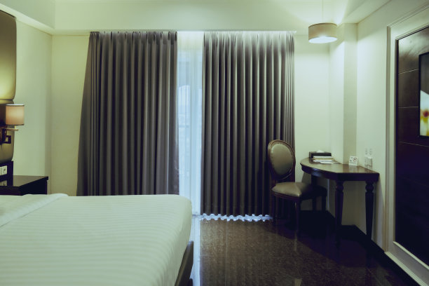 现代酒店客房，双人床，床头柜，电视机和窗户图片下载
