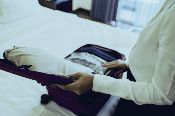 商务女士在酒店房间收拾行李图片下载
