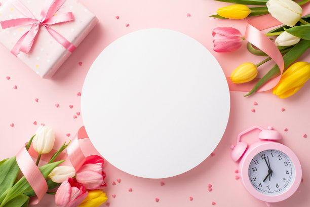 3月8日的概念。顶部视图照片的白色圆形花束彩色郁金香彩带礼盒闹钟和洒在孤立的粉彩粉红色背景与复制空间图片下载