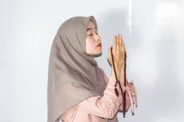 年轻的头巾妇女祈祷，孤立的背景图片下载
