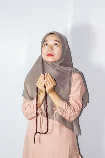 年轻的头巾妇女祈祷，孤立的背景图片下载