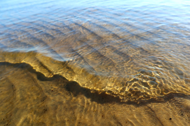 海水和沙滩在一个阳光明媚的夏日特写。图片下载