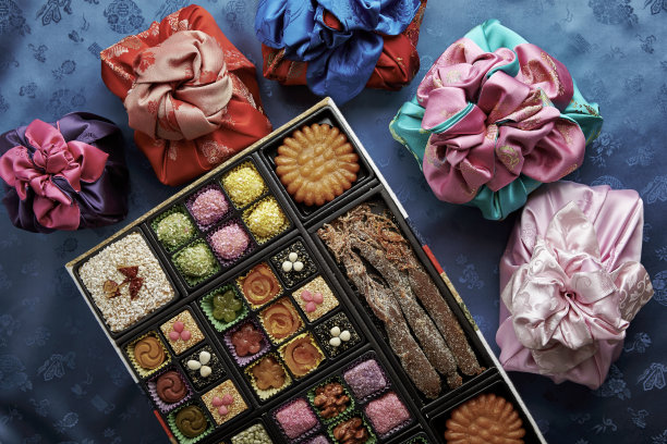 一个装满韩国糖果的盒子，周围是彩色包装的礼物图片下载