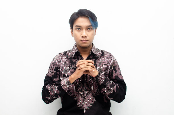 时尚的亚洲人在沉思的心情蓝色偷看boo头发穿着印度尼西亚蜡染好奇和认真思考。传统的印尼蜡染概念。图片下载