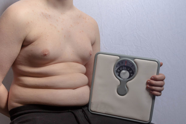 超重的白人少年，有体重秤图片下载