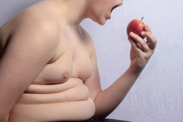 一个超重的少年拿着一个苹果图片下载